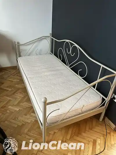 Beli dusek na singl krevetu sa belim metalnim okvirom