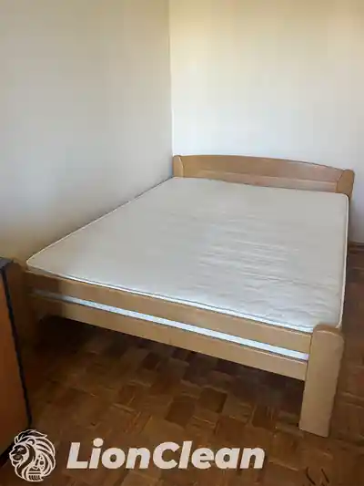Beli dusek na bracnom krevetu sa svetlim drvenim okvirom