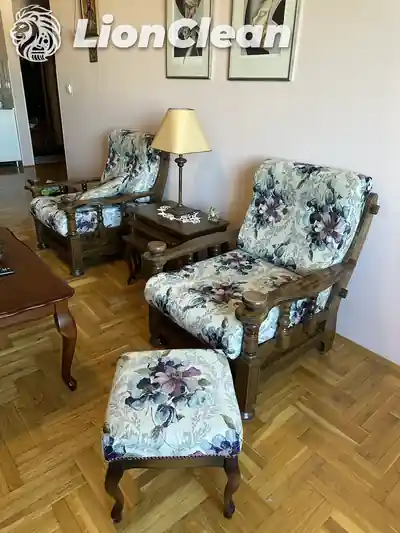 Dve fotelje i tabure sa cvetnom presvlakom oko malog drvenog stola
