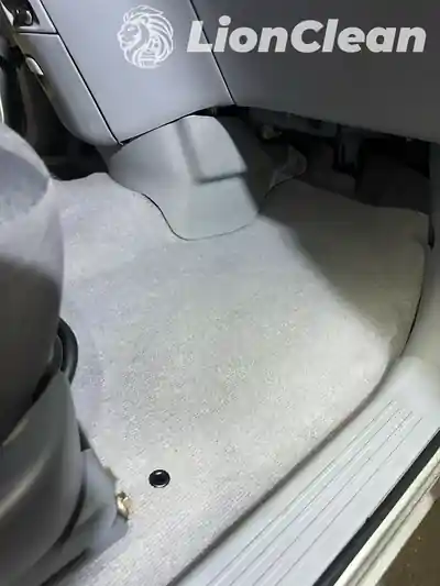 Ociscen svetlosivi pod iza prednjeg sedista automobila